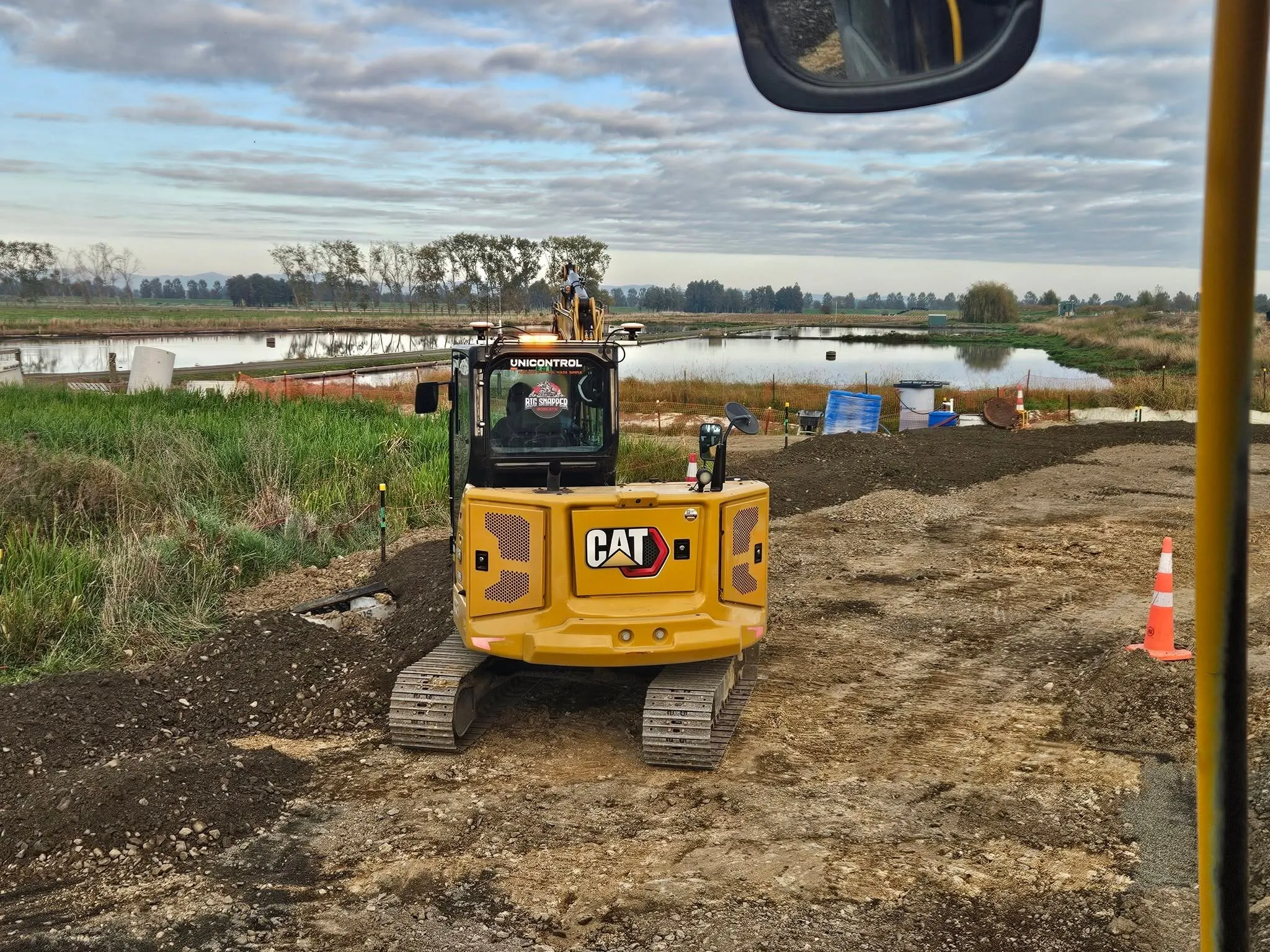 Big Snapper Bobcats Cat excavator working beside a pond on a Waikato site